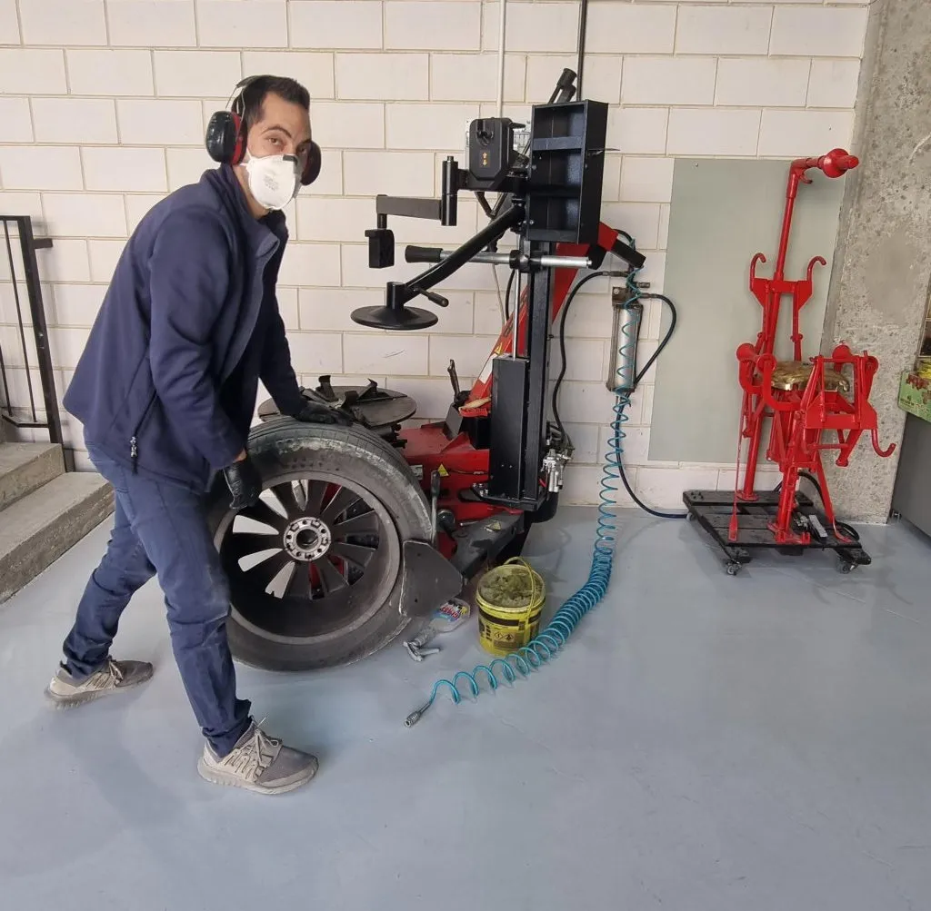 מכונאי בגסנר צמיגים מחליף צמיג על מכונת הרכבה